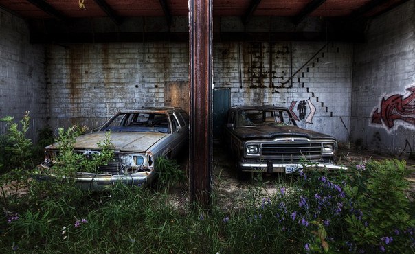 Два старых автомобиля прячутся в заброшенной мастерской в Северной Онтарио, Канада.