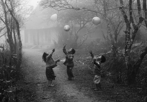 «Дети, принадлежащие к этнической группе хмонгов, играют воздушными шариками в тумане в Мок Чау, провинция Хаузянг, Вьетнам. Этот снимок был сделан в январе 2012 года».