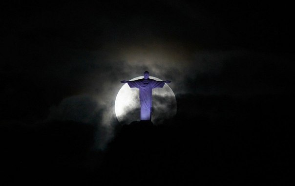 Полная Луна повисла над статуей Христа-Искупителя в Рио-де-Жанейро, Бразилия.