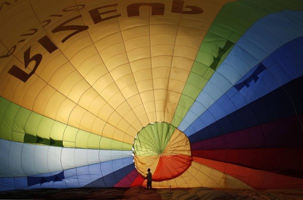 Пилот проверяет свой воздушный шар перед полётом в окрестностях города Эйлат, Израиль.
