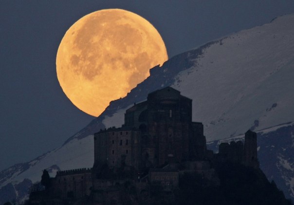 Полная луна над Альпами и Аббатством Святого Михаила на горе Пирчириано в 60 км от Турина, Италия.