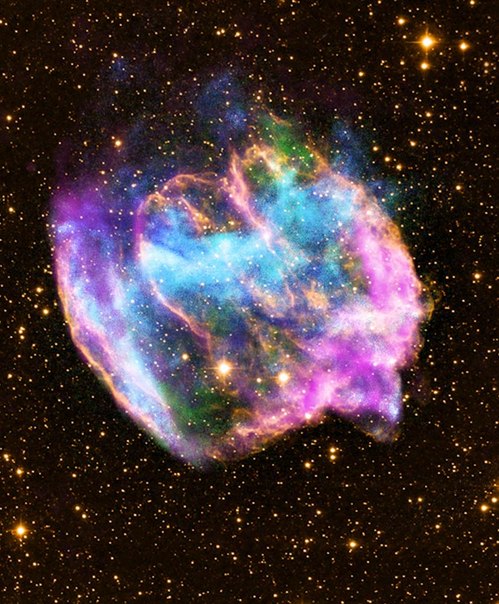 Это изображение из обсерватории Чандра, полученное 26 февраля, показывает сильно искаженный остаток сверхновой, которая может содержать самые последние черные дыры, образовавшиеся в галактике Млечный Путь. Цветное составное изображение остатка сверхновой W49B сочетает изображение в рентгеновских лучах от Чандры (синий и зеленый), радио данные от Very Large Array (розовый) и инфракрасные данные из обсерватории Паломар (желтый).
