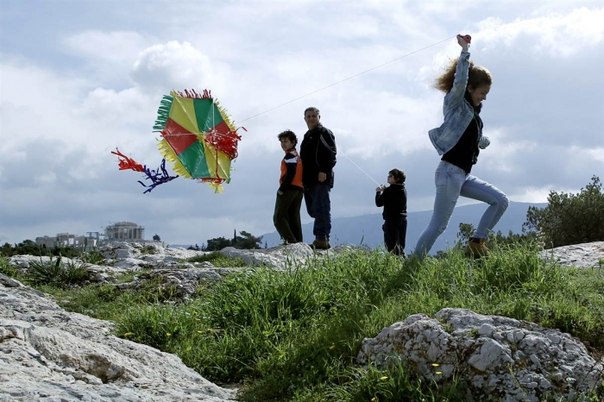 Девочка запускает воздушного змея неподалеку от Парфенона, Греция.