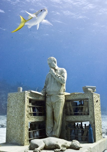 Рыба проплывает над скульптурой работы Джейсона де Кэйреса Тейлора "Потерянные мечты коллекционера" в Канкуне, Мексика. 
