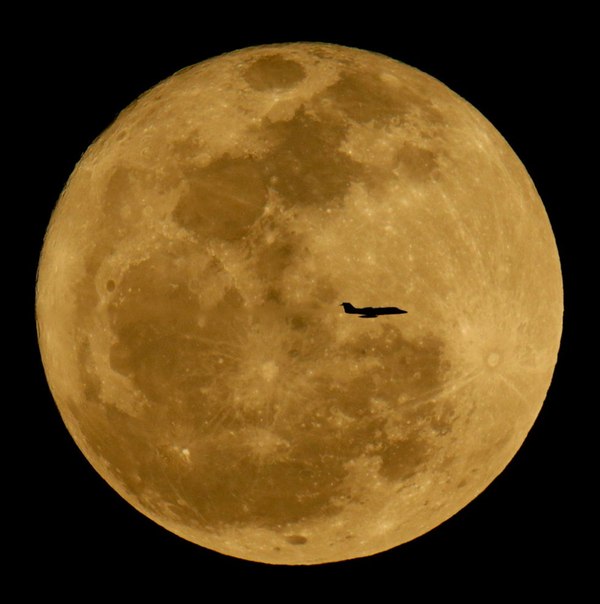 Самолёт летит на фоне восходящей Луны в небе над Финиксом, штат Аризона