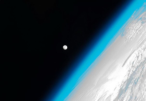 Ярко-бирюзовая атмосфера Земли и полный диск Луны - вот такие виды ежедневно открываются астронавтам из иллюминатора МКС