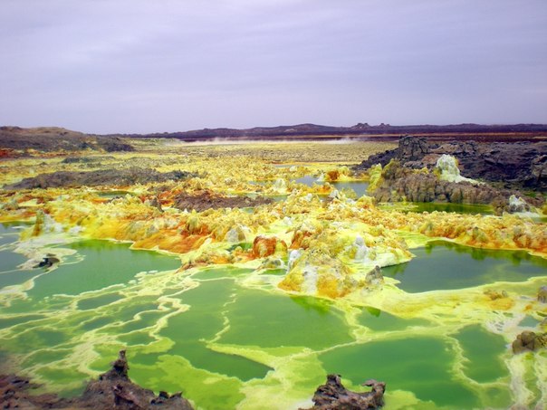 Вулкан Далол, Эфиопия. Неестественные цвета придают захватываемые по пути из недр сера и нефть. Озерцо зеленого цвета-это серная кислота.