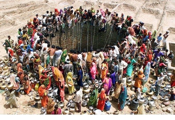 Люди добывают воду из большого колодца в деревне Натваргад в индийском штате Гуджарат