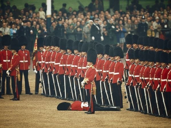 «Глазом не моргнув». Солдаты ирландской гвардии должны сохранять полное спокойствие в случае обморока товарища. Лондон, 1966 год. Автор фото: James P. Blair.