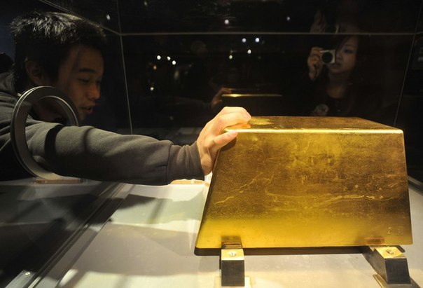 Посетитель касается полнотелого крупнейшего в мире слитка золота весом 220 килограмм (на сумму более 7,8 млн. долл. США по нынешним ценам). 2 декабря 2009 года.