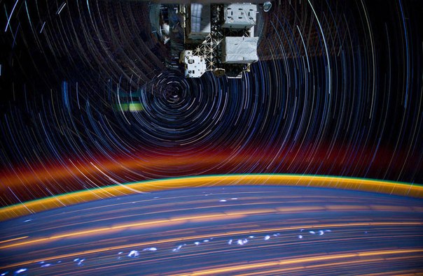 Снимок, сделанный на Международной космической станции. На фото причудливо смешались огни земных городов, вспышки звёзд и молний