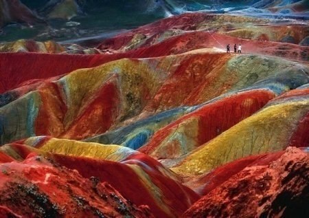 Это уникальное геологическое явление, известное как Danxia landform. Такие явления можно наблюдать в нескольких местах в Китае. Этот пример расположен в Zhangye, провинция Gansu. Цвет -результат накопленного в течении миллионов лет красного песчаника и других осадков, которые высохли, осели и окислились.