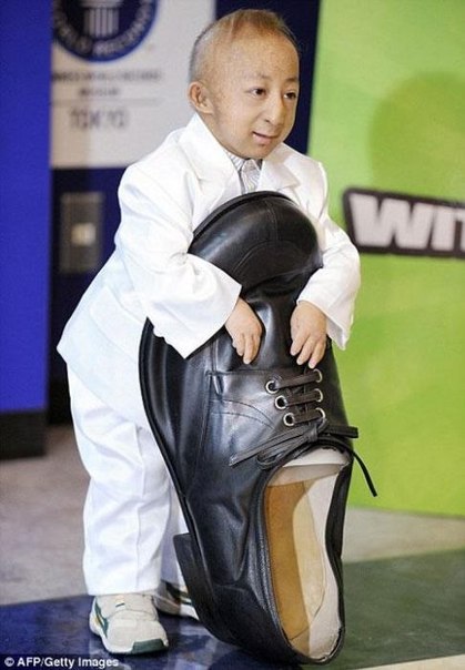 Самый маленький человек примерил самый большой ботинок.