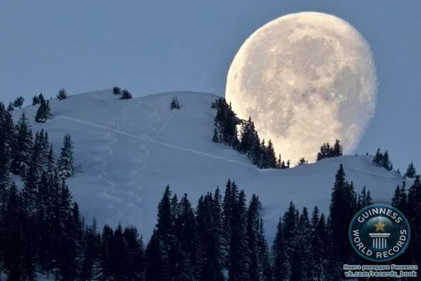 Самая большая уходящая луна на фоне горы Цвайершпитце (1858 метров над уровнем моря). Верхняя долина Рейна, Швейцария.