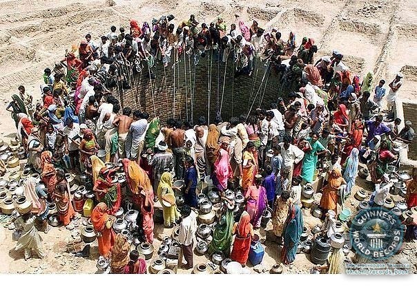 Люди добывают воду из большого колодца в деревне Натваргад в индийском штате Гуджарат.