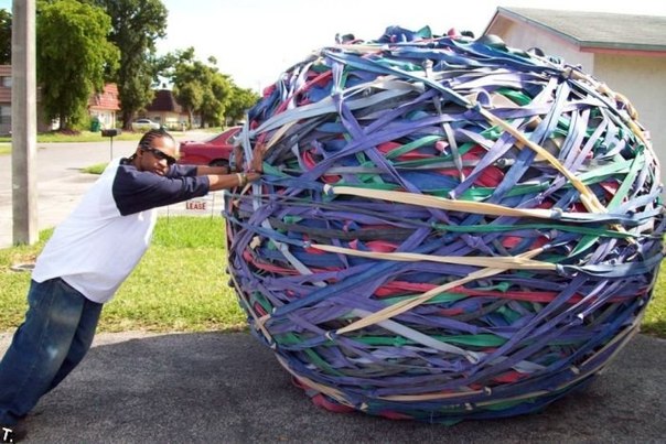 Джоел Вол из США толкает свой шедевр – самый большой шар из резиновых лент. 
