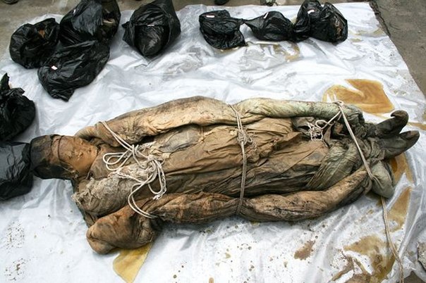 На стройке в Тайчжоу (это в восточной китайской провинции Чианьсу) археологи обнаружили гроб с женщиной, которая была похоронена примерно 700 лет назад. Останки её хорошо сохранились до наших дней. При жизни женщина была ростом не выше 1.5 метра. Само тело было завернуто в погребальные одежды – льняные лоскуты, хорошо пропитанные воском, и стёганное одело.