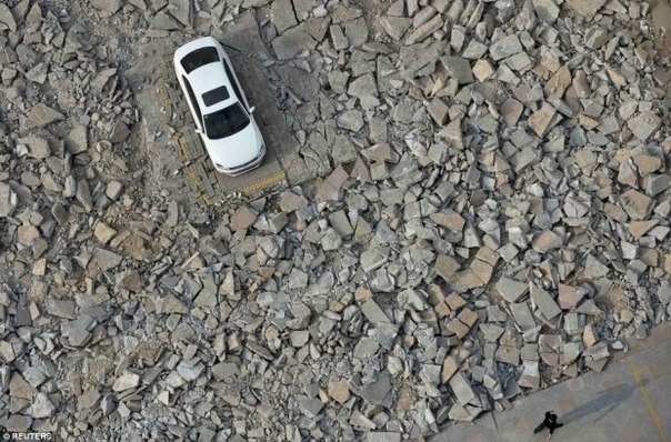 В китайском городе Тайюань строители, занятые в работах по расширению магистрали, десять дней ждали, пока владелец одной из машин заберет ее со стоянки, которая по проекту подлежала сносу.