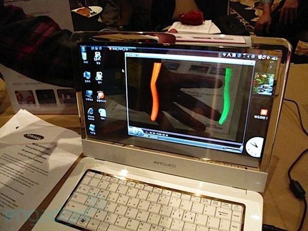 Южнокорейская компания Samsung представила первый в мире ноутбук с прозрачным экраном. Причем эта особенность не мешает работать и даже смотреть видео с яркой и четкой картинкой.