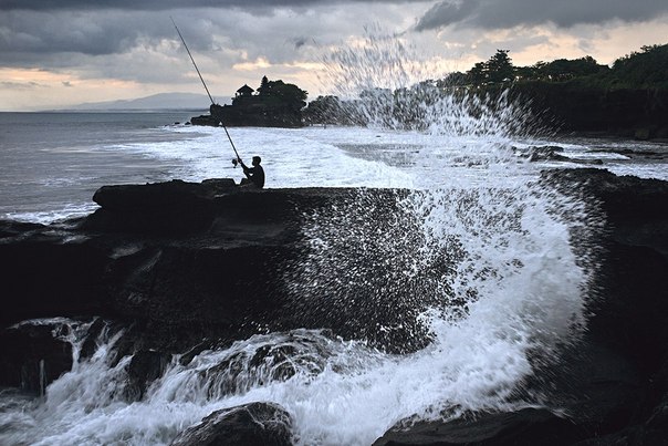 Балийский рыбак на фоне храма Танах-Лот 