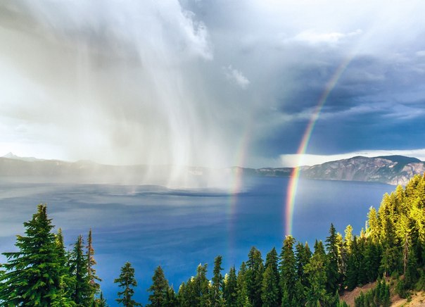 Зарождающаяся буря на поверхности озера Крейтер, штат Орегон, США. Двойная радуга — большая редкость. 
