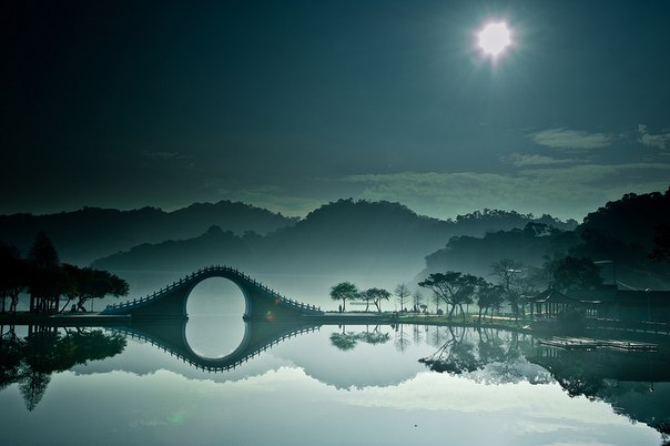 Мост Нефритового Пояса у западного берега Куньминского озера в Летнем дворце императора Цяньлуна. Этот каменный мост, сооружённый в XVIII веке, устроен таким образом, чтобы пропускать под собой императорскую ладью.