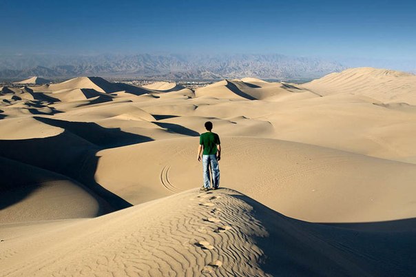 Пустыня, расположенная на юге Перу. Пески одной из самых засушливых пустынь планеты формируют массивные дюны. Вдали можно увидеть город Ика, который тоже кажется крошечным среди этих дюн.