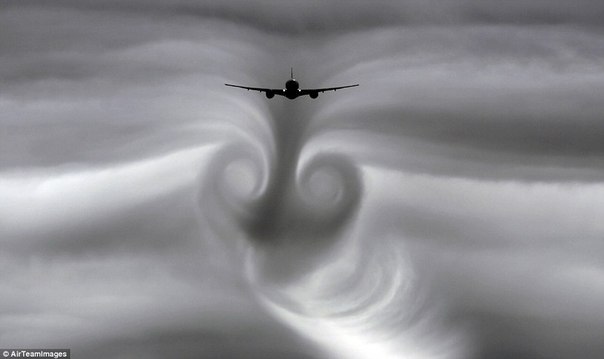 Пролетая через облака, самолёт оставляет след в виде торнадо.