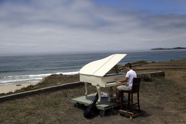 Студент музыкального училища играет на рояле на пляже в Халф Мун Бэй, штат Калифорния, 15 июля 2013 года.