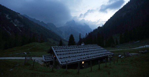 Свет горит в окне на альпийской молочной ферме Bindalm недалеко от Берхтесгадена на юге Германии, 11 июля 2013 года.