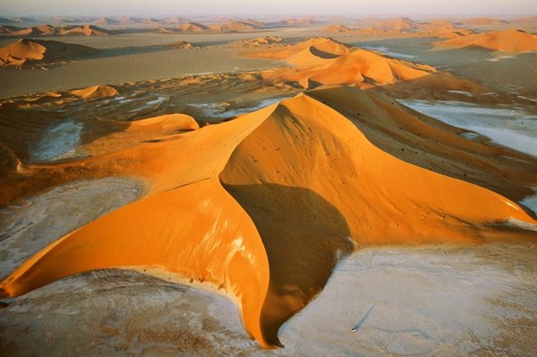 Звездообразные дюны в пустыне Руб-эль-Хали, Саудовская Аравия. Ветры, меняющиеся от сезона к сезону, создают похожие на пирамиды барханы с несколькими расходящимися от центра лучами. Такие дюны в основном растут вверх, а не в стороны – и их высота может достигать 300 метров.