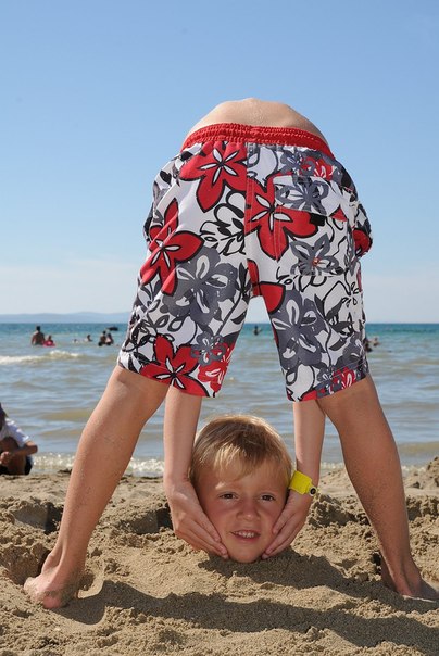 Два мальчика на пляже. Один закопан в песок, а другой держит его голову. Идея для тех, кто хочет сделать оригинальное фото на пляже.