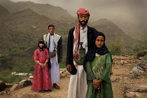 Тахани вышла замуж за своего мужа, когда ей было шесть лет, а ему – 25. Здесь они позируют с ее бывшей одноклассницей Гадой, тоже невестой, у их дома в Хадже, Йемен. Практически половина женщин в Йемене выходят замуж еще детьми.