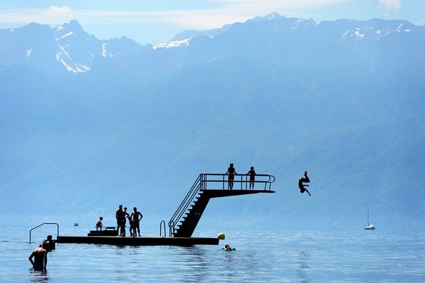 Дети прыгают в Женевское озеро в Лютри недалеко от Лозанны, Швейцария, 16 июня 2013 года. На заднем плане видны французские Альпы.