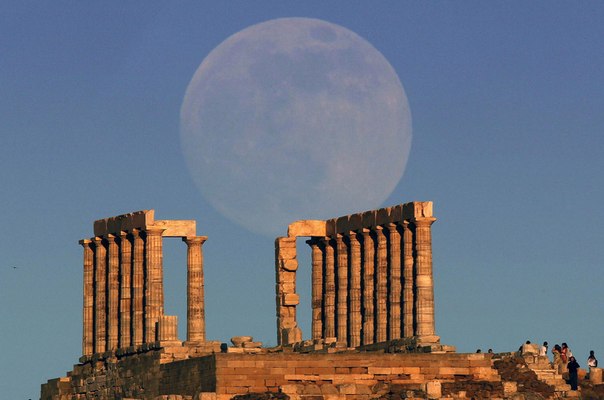 Полная Луна восходит над храмом Посейдона на мысе Сунион, Греция.
