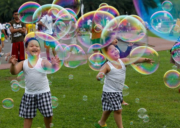 Дети играют мыльными пузырями в парке в Маниле, Филиппины.