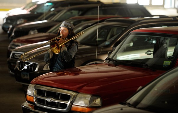 Джен Бэйкер, тромбонист из группы «Asphalt Orchestra», репетирует среди автомобилей, припаркованных в гараже на Уолтер-стрит в Нью-Лондоне, штат Коннектикут, 5 апреля 2012 года.