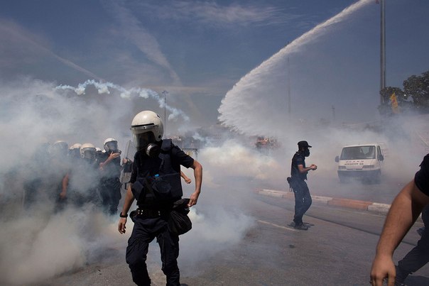 Стражи порядка при помощи водометов и слезоточивого газа разгоняет народ во время демонстрации на площади Таксим 11 июня 2013 года, Турция.