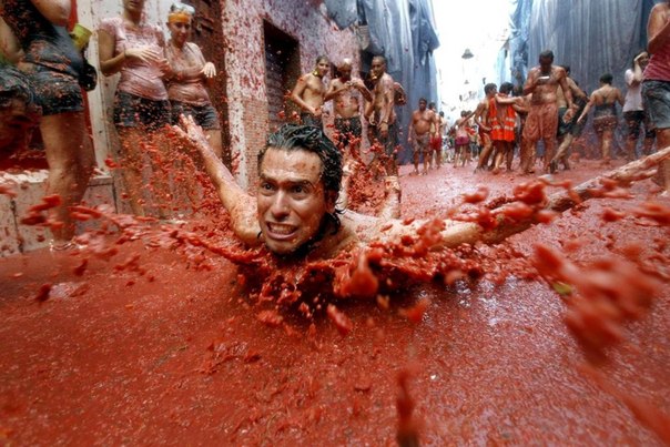 Парень плещется в реке томатного сока на фестивале Ла Томатина в испанском городе Буньоль. Главное событие праздника - часовой томатный бой, на который уходит около 125 тонн помидоров.