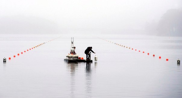 Рабочие размещают буйки на озере Банук перед началом Канадских Игр в Дартмуте, провинция Новая Шотландия, Канада