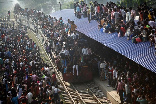 Переполненный поезд приближается к станции в городе Дакка, Бангладеш. 