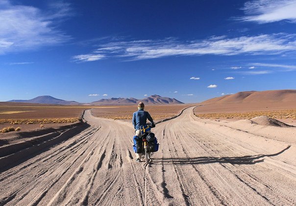 Равнины на юге Боливии. Велосипедист на развилке дорог. 
