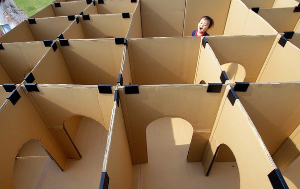 Ребёнок играет в лабиринте из картонных коробок в парке в Токио, Япония