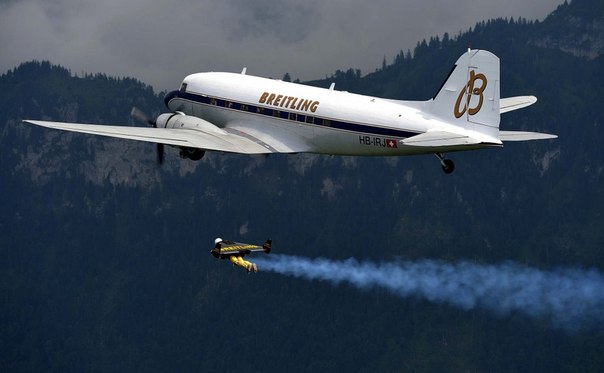 Ив Росси (Yves Rossy), известный как Jetman, летает у озера Люцерн, Швейцария, пока зрители наблюдают за ним с борта самолета. 