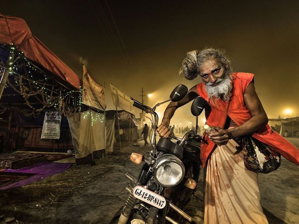Индус с мотоциклом на фестивале Маха Мела в Аллахабаде, Индия.
