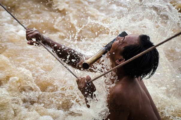 Лаос, водопад в бушующей реке Меконг. Рыбак занимается ловлей мигрирующих рыб. Одна ошибка здесь может привести к смерти. 