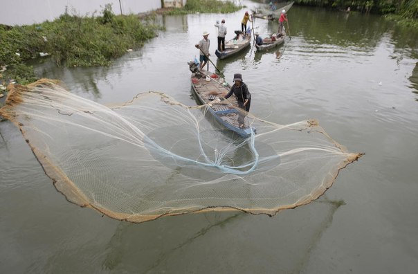Рыбак забрасывает сеть в канал в деревне Prek Phnoa в 13 километрах к северу от Пномпеня, Камбоджа.