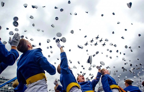 Кадеты бросают в воздух свои головные уборы во время церемонии выпуска в Академии ВВС США. 