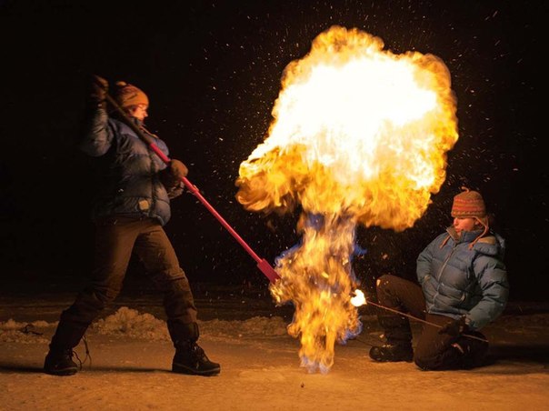 Эколог Кэти Уолтер Энтони (справа) поджигает метан, высвобожденный из пузыря в слое льда.