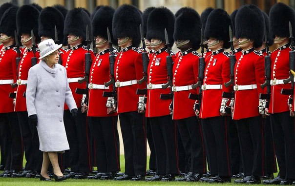 Британская королева Елизавета II в ходе церемонии передачи флага проверяет охранников в Виндзорском замке. У британских монархов будни расписаны миллионом разных церемоний. 